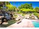 Scenic waterfall feature with lush landscaping, rocks, and benches near the pool at 1633 E Lakeside Dr # 25, Gilbert, AZ 85234