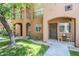Charming condo entrance with wreath-adorned door, quaint seating area, and desert-friendly landscaping at 1718 W Colter St # 184, Phoenix, AZ 85015