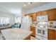 Bright kitchen open to living area, featuring wooden cabinets and white appliances at 1718 W Colter St # 184, Phoenix, AZ 85015