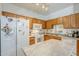 Kitchen with oak cabinets, white appliances, laminate countertops, and a kitchen island at 1718 W Colter St # 184, Phoenix, AZ 85015