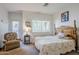 Bright main bedroom features a full bed, a window with blinds, and an armchair at 1718 W Colter St # 184, Phoenix, AZ 85015