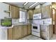 Bright kitchen area features wood cabinets, a white oven, microwave, countertops and sink at 17200 W Bell Rd # 652, Surprise, AZ 85374