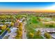 A birds eye view of the property, close to a golf course, surrounded by lush trees, other homes, and scenic mountain backdrop at 18410 N 104Th Ave, Sun City, AZ 85373