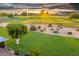 The backyard has lush green landscaping with golf course views in the background, creating a serene outdoor retreat at 18410 N 104Th Ave, Sun City, AZ 85373