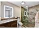 Modern bathroom with an illuminated mirror, stone shower, and granite-topped vanity at 18410 N 104Th Ave, Sun City, AZ 85373