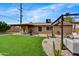 Relax in this backyard oasis featuring lush green turf, desert landscaping, a covered patio, and inviting outdoor seating at 18601 N 45Th Dr, Glendale, AZ 85308