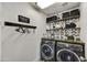 Efficient laundry room showcases modern washer and dryer units with stylish decorative shelving at 18601 N 45Th Dr, Glendale, AZ 85308