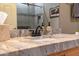 Close-up of bathroom vanity with granite countertop, bronze faucet, and decorative soap dispenser at 19700 N 76Th St # 2091, Scottsdale, AZ 85255