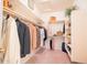 Walk-in closet featuring shelving, racks and organized storage, with pink carpet at 19700 N 76Th St # 2091, Scottsdale, AZ 85255