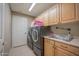 Functional laundry room with washer, dryer, sink, and upper cabinets for storage at 19700 N 76Th St # 2091, Scottsdale, AZ 85255