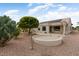 Large backyard with desert landscaping, patio, mature trees, and solar panels on the home at 20017 N Cielo Ct, Surprise, AZ 85374