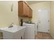 Laundry room featuring a sink, washer, dryer, and wooden cabinets at 20017 N Cielo Ct, Surprise, AZ 85374