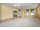 Carpeted living room with ceiling fan, chandelier, view to front yard and door, and tile flooring at 20017 N Cielo Ct, Surprise, AZ 85374