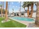 Large backyard pool surrounded by well-maintained artificial grass, palm trees, and a covered patio area at 2026 S Emerson --, Mesa, AZ 85210