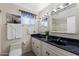 Bathroom features dual vanities, granite counters, white cabinets, tile floors, and a framed mirror at 2218 W Curry St, Chandler, AZ 85224