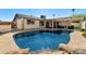 Backyard pool with rock waterfall feature, lush landscaping, and a covered patio area for outdoor enjoyment at 2218 W Curry St, Chandler, AZ 85224
