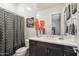 Well-lit bathroom with a shower/tub, dark vanity, and decorative mirror at 23060 E Sonoqui Blvd, Queen Creek, AZ 85142