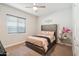 Cozy bedroom with plush carpeting, a stylish bed with a tufted headboard, and a window for natural light at 23060 E Sonoqui Blvd, Queen Creek, AZ 85142