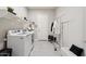 Functional laundry room with modern washer and dryer, shelving, and clothing rack at 23060 E Sonoqui Blvd, Queen Creek, AZ 85142