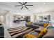Open living space featuring tile floors, a modern gray sofa with yellow accents, and an open view to the kitchen at 23060 E Sonoqui Blvd, Queen Creek, AZ 85142