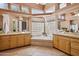 Spacious bathroom boasts a soaking tub with glass block windows, dual vanities, and elegant tile work at 23520 N 80Th Way, Scottsdale, AZ 85255