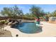 Inviting backyard pool with rock waterfall feature, surrounded by lush greenery and a brick wall at 23520 N 80Th Way, Scottsdale, AZ 85255