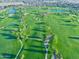 Stunning aerial view of a lush green golf course with ponds and winding paths at 247 E Las Puertas Ln, Queen Creek, AZ 85140