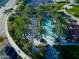 Aerial view of pool with palm trees, lawn chairs, and nearby tennis courts at 247 E Las Puertas Ln, Queen Creek, AZ 85140