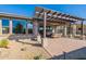 Backyard with pergola, outdoor seating, decorative rock and desert landscaping at 247 E Las Puertas Ln, Queen Creek, AZ 85140