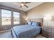 This bedroom features a blue bedspread, ceiling fan and two windows at 247 E Las Puertas Ln, Queen Creek, AZ 85140