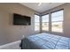 This bedroom features a large window, TV and blue bedspread at 247 E Las Puertas Ln, Queen Creek, AZ 85140