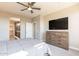This bedroom features a ceiling fan, dresser with a TV, and an ensuite bathroom at 247 E Las Puertas Ln, Queen Creek, AZ 85140
