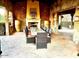 Inviting outdoor dining area with stone fireplace and ample seating for memorable gatherings at 247 E Las Puertas Ln, Queen Creek, AZ 85140