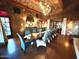 Beautiful dining room with long table, comfortable upholstered chairs, stone walls, and unique chandelier at 247 E Las Puertas Ln, Queen Creek, AZ 85140