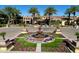 Beautiful front entrance to the property with mature palms, a fountain, and colorful landscaping at 247 E Las Puertas Ln, Queen Creek, AZ 85140