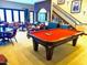 Bright game room features a red felt pool table and comfortable seating in a modern community clubhouse at 247 E Las Puertas Ln, Queen Creek, AZ 85140