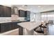 Modern kitchen featuring a large island with seating, stainless steel appliances, and stylish backsplash at 247 E Las Puertas Ln, Queen Creek, AZ 85140