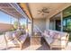 Spacious covered patio with dual sofas and a fire pit provides an inviting outdoor lounge area at 247 E Las Puertas Ln, Queen Creek, AZ 85140