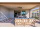Covered patio with brick flooring offers a relaxing outdoor space, featuring a fire pit table and cozy seating at 247 E Las Puertas Ln, Queen Creek, AZ 85140
