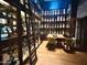 Elegant wine room featuring custom shelving, a built-in ladder, and a charming tasting table for a luxurious experience at 247 E Las Puertas Ln, Queen Creek, AZ 85140