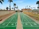 Community shuffleboard courts with seating and views of palm trees at 25 S 102Nd St # 47, Mesa, AZ 85208