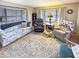 Bright living room with a patterned sofa, recliner chairs, decorative rug, and large windows at 25 S 102Nd St # 73, Mesa, AZ 85208
