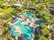 An aerial shot of a community pool, with multiple pools and splashpads surrounded by shady areas at 30406 N 116Th Ln, Peoria, AZ 85383