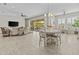 Open-concept living room with tile floors, slider to patio, and a dining area at 30406 N 116Th Ln, Peoria, AZ 85383