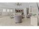 Open-concept living room featuring tile floors, modern furniture, and an open flow to kitchen and dining areas at 30406 N 116Th Ln, Peoria, AZ 85383