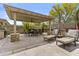 A covered patio features a dining table, chairs, lounge seating, and a hammock for the ultimate outdoor retreat at 30406 N 116Th Ln, Peoria, AZ 85383