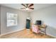 Bright bedroom with wood floors, a ceiling fan, a writing desk, and a pink velvet chair at 3149 W Danbury Dr, Phoenix, AZ 85053