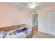 room featuring light wood floors and a rattan bed frame. Natural light fills the room at 3149 W Danbury Dr, Phoenix, AZ 85053