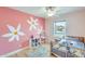 room with light wood floors, whimsical daisy wall art, and a rattan bed frame at 3149 W Danbury Dr, Phoenix, AZ 85053