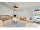 Cozy living room with brick fireplace, hardwood floors, a ceiling fan, and backyard access at 3149 W Danbury Dr, Phoenix, AZ 85053